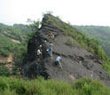 Photo of scientists collecting unweathered samples along a narrow road north of Beijing.