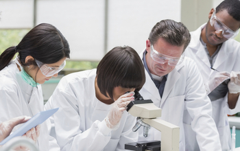 researchers with a microscope