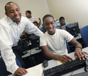 Professor with students working on a computer