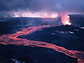 Photo taken at night of incandescent lava flowing downslope from a vent at Icelands Krafla volcano.