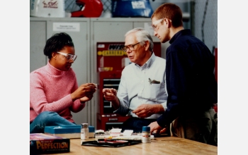 Students and a professor discuss engineering concepts during a Learning Factory exercise.