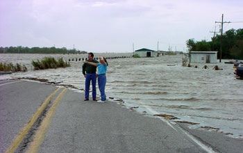 two people standing next to a flooded highway in Louisiana.