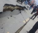 People standing next to road damaged by earthquake