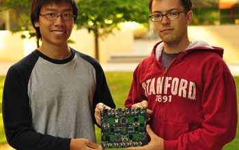 Graduate students Sam Fok and Alex Neckar hold a brain-inspired computational platform