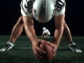 Football player holding football on ground and looking behind