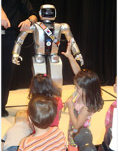 Photo of children reaching out for Jaemi Hubo, an NSF-funded international robotics collaborative.