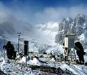 researchers checking instruments on top of a mountain