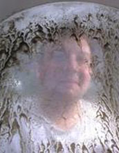 Researcher behind screen with oyster larvae at the Whiskey Creek Shellfish Hatchery.