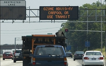 cars on highway and display showing ozone advisory