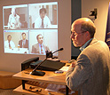 Photo of host in studio and four people on a screen