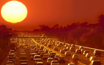 cars in traffic on a highway and a big sun