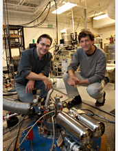 Photo of researchers kneeling behind a dilution refrigerator
equipped for microwave measurements.