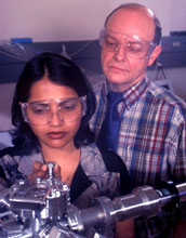 Graduate student Tazrien Kamal shows Prof. Dennis Hess a treated sample in his lab
