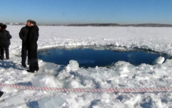 People standing next to hole in the ice at Russia's Lake Chebarkul, said to be caused by the meteor.