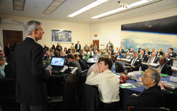 Representative Daniel Lipinski speaking in front of a standing-room-only crowd.