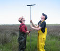 Photo of Andrew Kemp in red and Simon Engelhart in yellow collecting sediment cores.