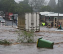 A woman in Australia awaits rescue on a car roof.