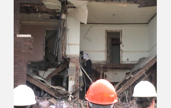 Researchers watch as an Indiana Task Force member enters the partially collapsed building.