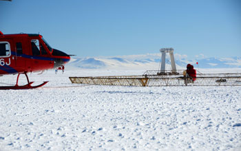 Photo of a helicopter preparing to launch SkyTEM mapping technology on the Antarctic sea ice.