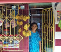 Photo of a woman standing at the door of her store.