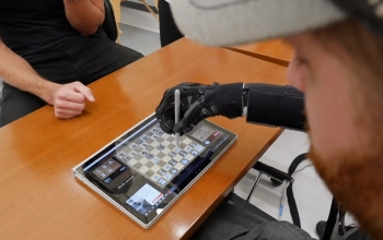 robotic arm playing chess on a tablet