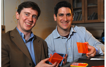 Photo of Marc Baldo and Shalom Goffri of MIT holding examples of organic solar concentrators.