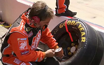 Member of pit crew checks a tire