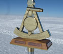 Photo of 2011 bronze marker designating the geographic South Pole.