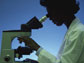Image of a researcher peering through a microscope.
