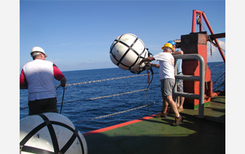 Photo of researcher Jamie Austin deploying a sound source and wave recorder.