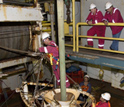 Photo of crew on JOIDES Resolution deploying an underwater camera system before drilling.