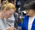 Photo of scientists Adelie Delacour and Chieh Peng working at the onboard sampling table.