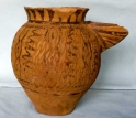 Photo of a strainer spouted pitcher painted and impressed in a pattern of connected ovals.