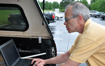 atmospheric scientist Kevin Knupp working on a lap-top connected to a radiosonde system.