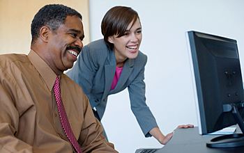 Photo of a man and a woman at computer screen.