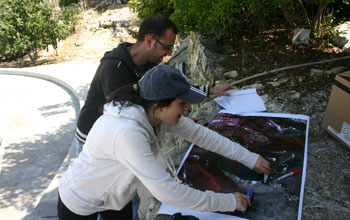 Research assistants review satellite imagery during a field visit