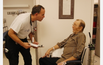 Following Hurricane Katrina in Sept. 2005, a doctor talks to a patient with a broken neck.