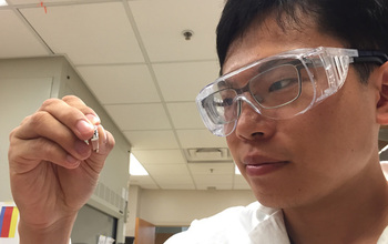 Student holding a sample for rsearch in the lab