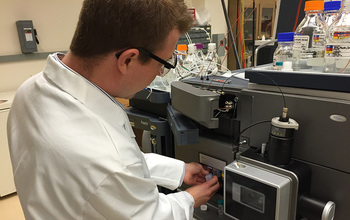 Georgia Tech postdoctoral fellow Jay Forsythe loads a sample into a mass spectrometer