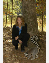 Photo of Duke University Lemur Center Director Anne D. Yoder kneeling with a ring-tailed lemur.