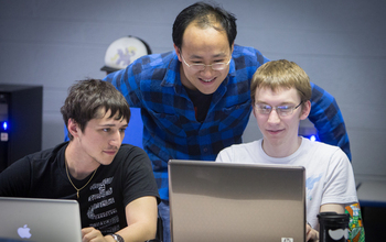 professor Yunsheng Wang working with two students.