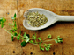 oregano sprig with dried on a wood table