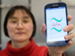 researcher holds smartphone with the app displayed