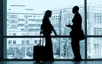 Photo of two people standing in front of a window