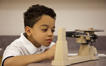 Student in science class with balance.