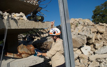 Researcher Robin Murphy  next to damaged buildings