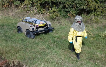 person in protective suit with a robotic vehicle