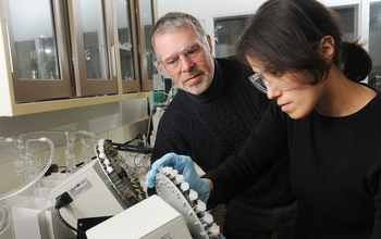 Researcher Robert Hazen works with an early career researcher in a lab.