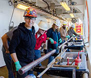 Zealandia on deck: a sediment core obtained through deep-sea drilling is pored over by scientists.