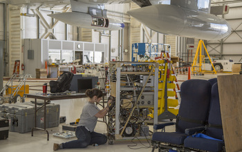 woman working in a facility to  mount air-sampling instruments on airplane